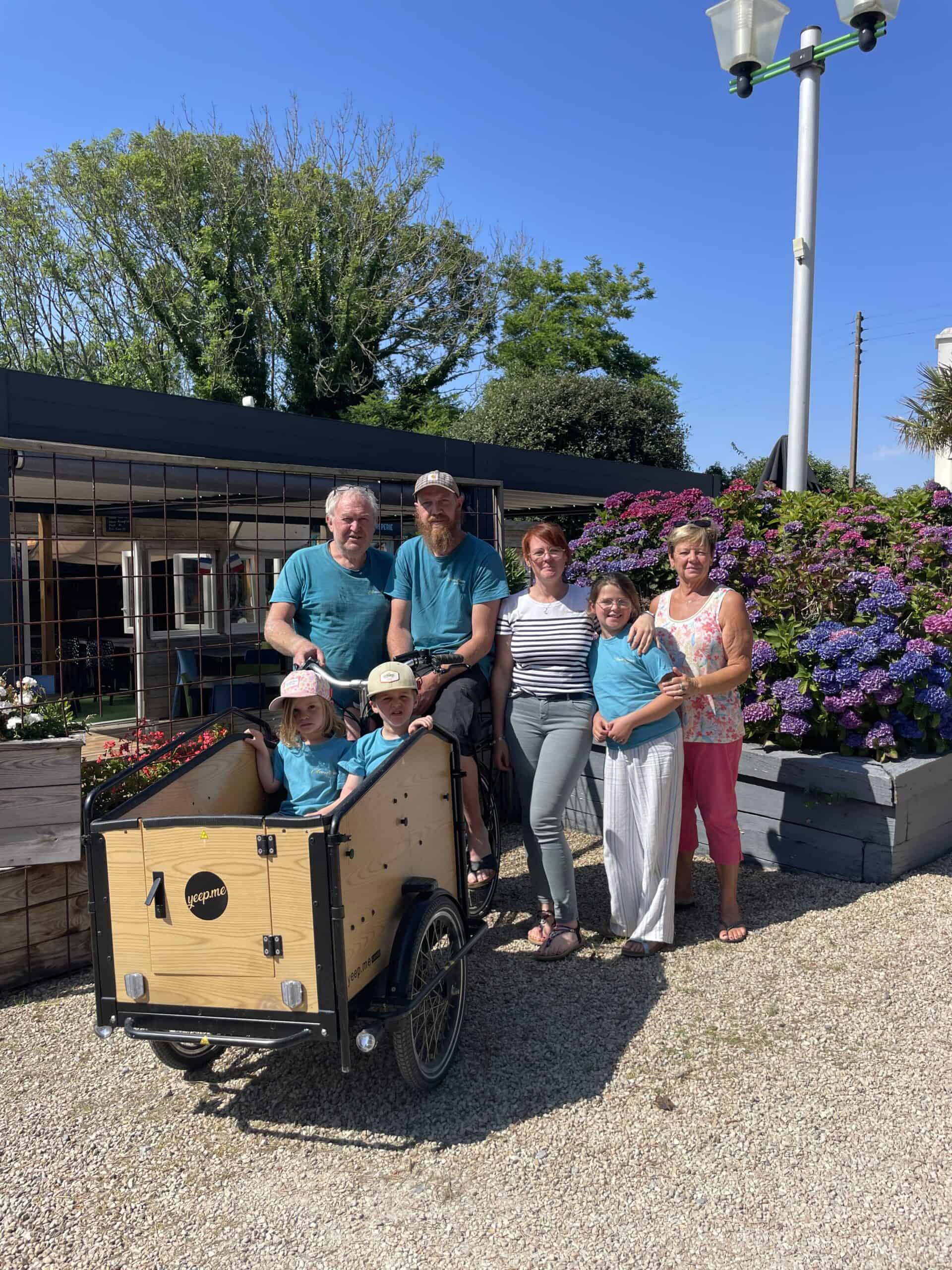 Famille posant avec vélo cargo ensoleillé