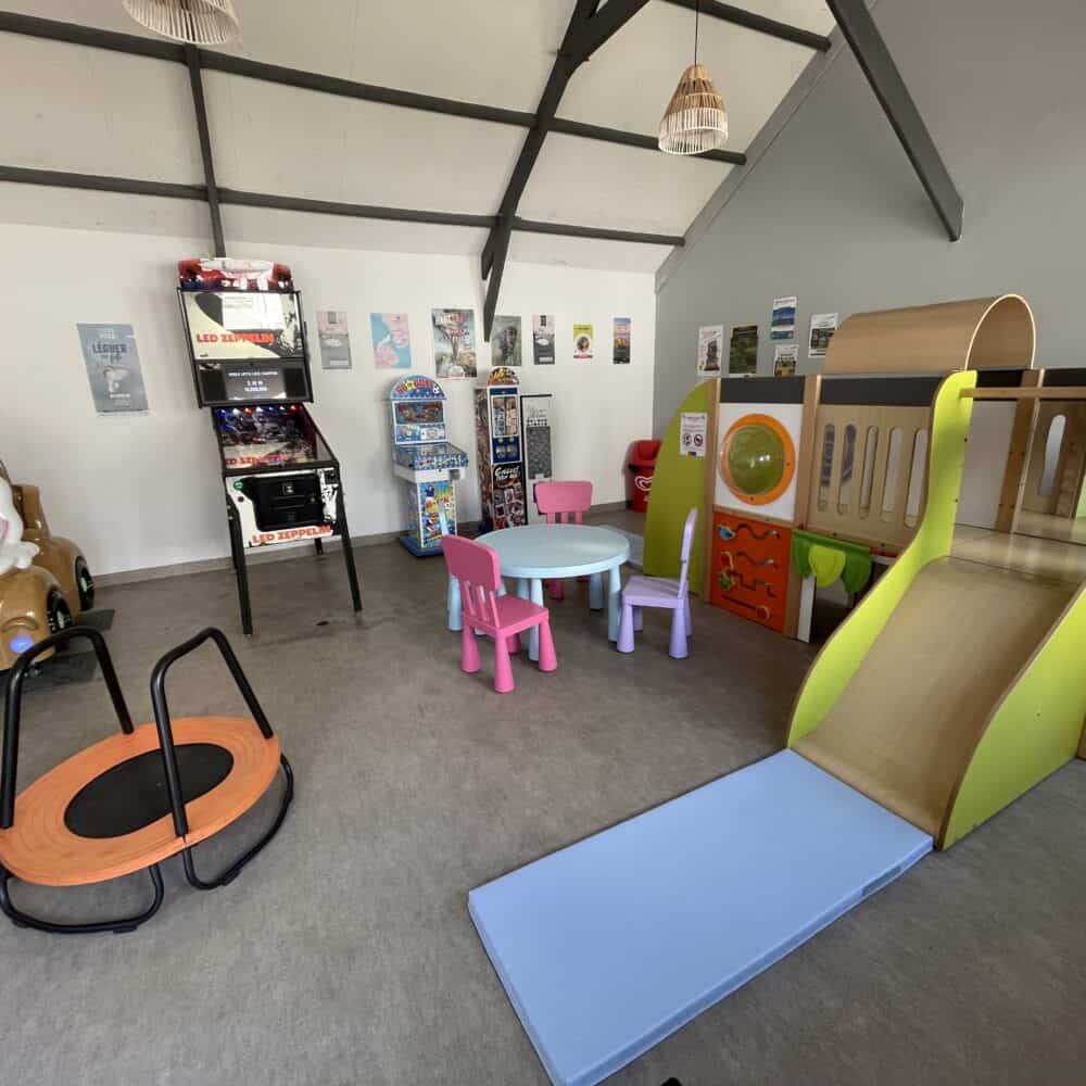 Espace de jeux intérieur avec toboggan et arcade